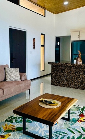 Ferienhaus Promnitz Costa Rica mieten: hoher, luftiger Raum mit Couch, Tisch und Küchenbereich
